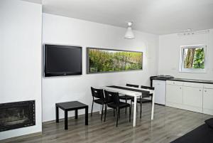 a dining room with a table and chairs and a tv at Zielony Cypel in Lubniewice