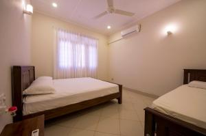 a bedroom with two beds and a window at First House Mihintale in Mihintale