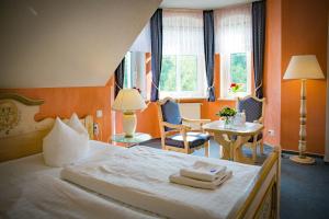 a hotel room with a bed and a table and chairs at Hotel & Restaurant Waldschlösschen in Kyritz +58 photos