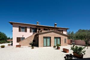 una casa grande con plantas delante en Agriturismo La Rosa Montefalco, en Montefalco