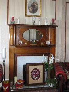 a living room with a fireplace with a mirror above it at Fairhaven Hotel in Llandudno