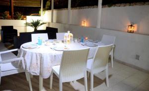a white table with white chairs and a white table cloth at Leca's House Appartamenti a 100m dal mare in Gagliano del Capo