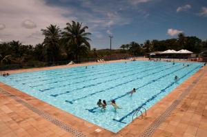 a large swimming pool with people in the water at Hotel SESI Valença in Valença