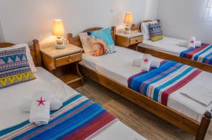 two twin beds in a room with two lamps at Angeliki's Studios Paros in Parikia