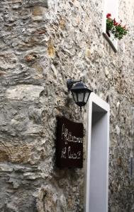 a stone building with a sign on the side of it at Affittacamere Al Civico 18 in Viggianello