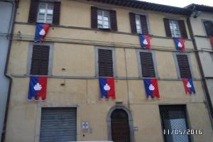 un edificio con banderas a un lado. en La Casetta sul Corso en Gubbio