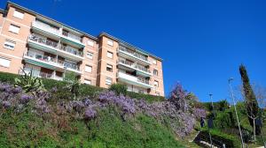 a building on a hill with purple flowers in front of it at Carmen Seaview & Beach - Apartment in Montgat