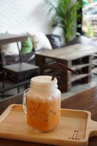 een drankje in een pot op een dienblad op een tafel bij Krit Hostel in Bangkok