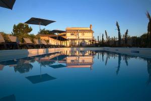 a large swimming pool with chairs and an umbrella at Casale905 in Crecchio