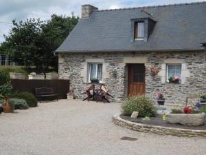 an old stone house with a patio in front of it at Les Gites de Kerroyal in Garlan