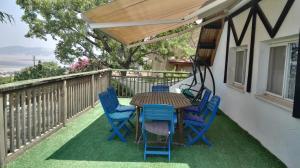 - une table et des chaises sur une terrasse avec un parasol en bois dans l'établissement Villa Billy, à Gan Ner