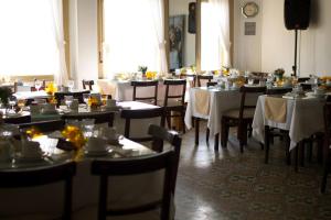 un comedor con mesas y sillas con mantel blanco en Hotel Colón, en Piriápolis