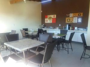 una sala da pranzo con tavoli, sedie e bancone di Pousada Dunas Beach a Canoa Quebrada