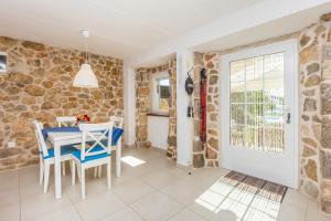 a dining room with a table and chairs and a stone wall at Holiday Home Lara in Brzac