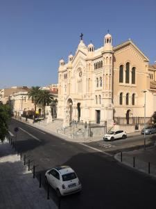 ein weißes Auto, das vor einem Gebäude parkt in der Unterkunft Le Royal in Reggio di Calabria