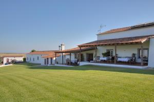 a house with a large lawn in front of it at Monte Da Morena Agro-Turismo in Serpa