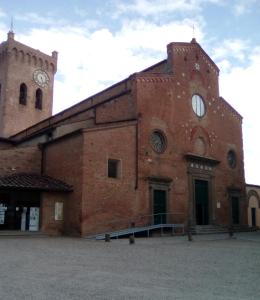 un grand bâtiment en briques avec une tour d'horloge dans l'établissement Ostello San Miniato, à San Miniato