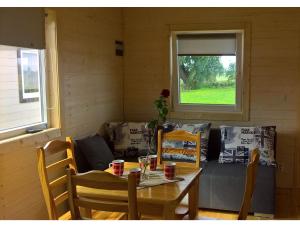 a table and chairs in a room with a couch at Domki pokoje pod Wierzba in Sarbinowo