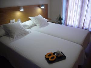 two white beds with a tray with a pair of scissors at Littore Tormes Alojamiento, Parking gratis y Piscina in Salamanca