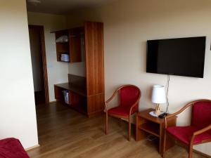 a hotel room with two chairs and a flat screen tv at Hotel Smyrlabjörg in Skálafell