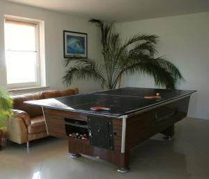 a ping pong table in a living room at Domki pokoje pod Wierzba in Sarbinowo