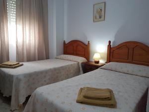 sypialnia z dwoma łóżkami i lampą na stole w obiekcie Playa La Caleta CADIZ Barrio La Viña PARKING GRATIS w Kadyksie