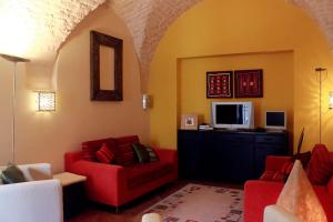 マルティナ・フランカにあるB&B Nel Centro Storicoのリビングルーム(赤いソファ2台、テレビ付)