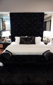 1 dormitorio con 1 cama grande y cabecero negro en Luxury Resort Suites@ Sunway City en Petaling Jaya