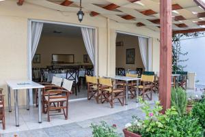 patio ze stołami i krzesłami oraz jadalnią w obiekcie Cretan Sun w mieście Platanes