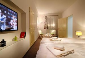 シビウにあるT19 Apartmentのベッド2台、薄型テレビが備わるホテルルームです。