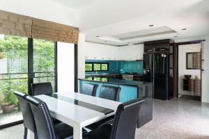 a kitchen with a white table and chairs at Baan Thai Surin Garden in Surin Beach
