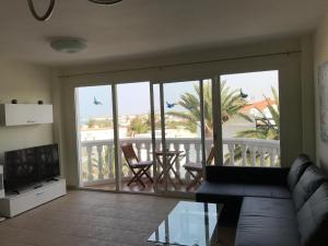 salon z kanapą i widokiem na balkon w obiekcie Vivienda Vacacional Maga w Corralejo