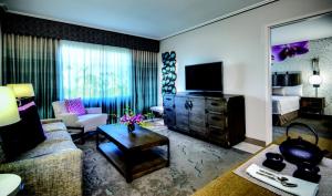 ein Wohnzimmer mit Sofa und TV in einem Zimmer in der Unterkunft Universal's Loews Royal Pacific Resort in Orlando
