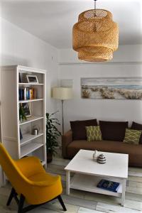 a living room with a couch and a table and a yellow chair at Home Sweet Apartment in Bük