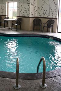 a swimming pool in a hotel with chairs and a table at Sleep Inn & Suites Galion in Galion