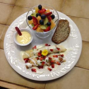 - une assiette de nourriture avec des fruits et un bol de pain dans l'établissement Auberge Les Blancs Moutons, à Saint-Laurent-de-l'ile d'Orleans