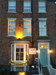 ein Backsteingebäude mit einer Tür und einem Schild darauf in der Unterkunft Sandpiper House in Whitby