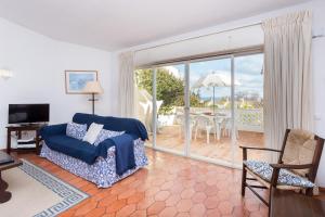 uma sala de estar com um sofá e uma porta de vidro deslizante em Casa da Praia 98 em Luz