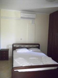 una piccola camera da letto con un letto con lenzuola bianche di Calypso Luxury Studios a Vassiliki