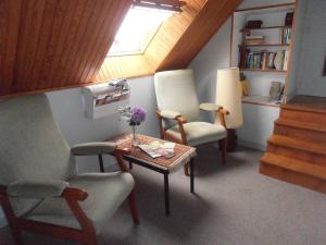 Zimmer mit 2 Stühlen, einem Tisch und einem Fenster in der Unterkunft La Clôture in Lanouée