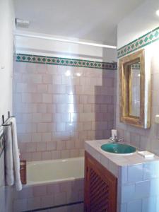 a bathroom with a sink and a tub and a mirror at Casita Buena Vista in Bubión