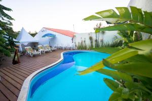 a swimming pool in a backyard with a wooden deck at Pousada dos Quatro Cantos in Olinda