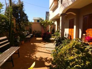 a group of benches sitting outside of a building at Antsirabe Hotel in Antsirabe