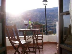 a table with a bottle of wine and two glasses at Casita Buena Vista in Bubión