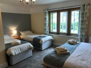 a bedroom with two beds and a window at Halfway House Inn Country Lodge in Yeovil