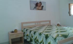 a bedroom with a bed and a picture on the wall at Il Pergolato in Torre Pali
