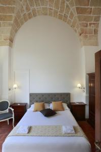 una camera da letto con un grande letto e un muro in pietra di Villa Scinata Dimora Storica a Nardò