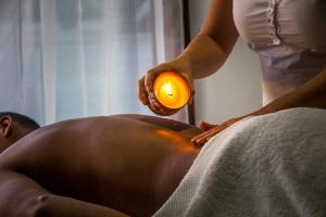 a woman giving a man a bath in a tub at Le Relais de Marambaia in Barra de Guaratiba