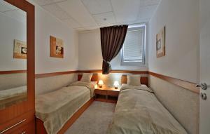 a room with three beds and a window and a table at Apartman Afrodita 1 in Bardejovské Kúpele