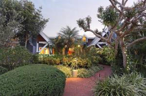 une maison avec un jardin et une passerelle en briques rouges dans l'établissement Serendipity Country House & Restaurant, à Wilderness